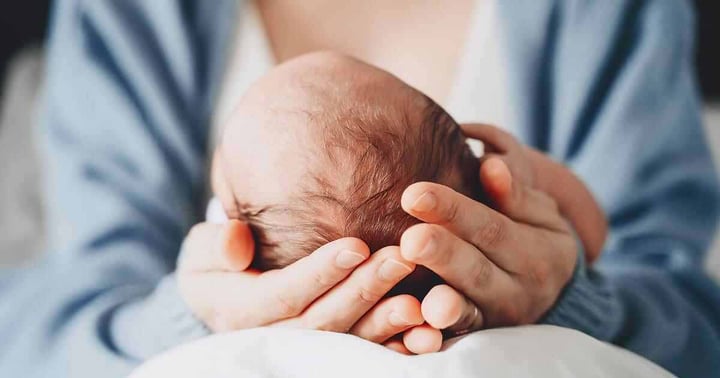 mother-holding-newborn-head