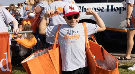 boy-flexes-muscles-wearing-lakewood-all-about-the-orange-shirt-at-community-event