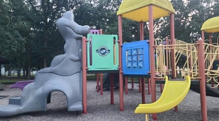 colorful-community-playground-with-dinosaur-sculpture-and-play-equipment