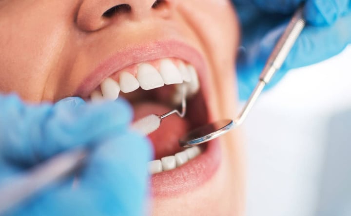 dentist-examines-patients-teeth-with-dental-tools-during-checkup
