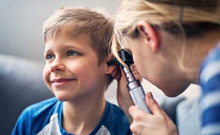 doctor-examines-smiling-boys-ear-with-otoscope-during-checkup