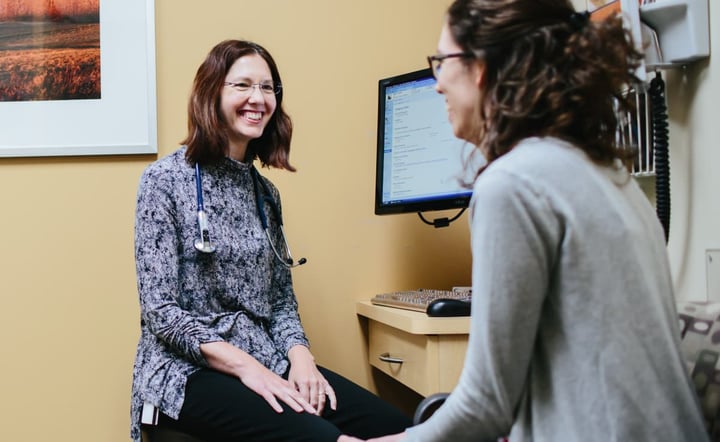 female-doctor-smiling-during-patient-consultation-in-exam-room