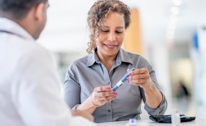 Woman holding a insulin pen that is used to do a medical injection. 