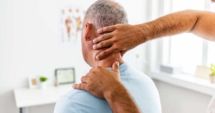 Doctor's hands using a technique on a patient's neck.