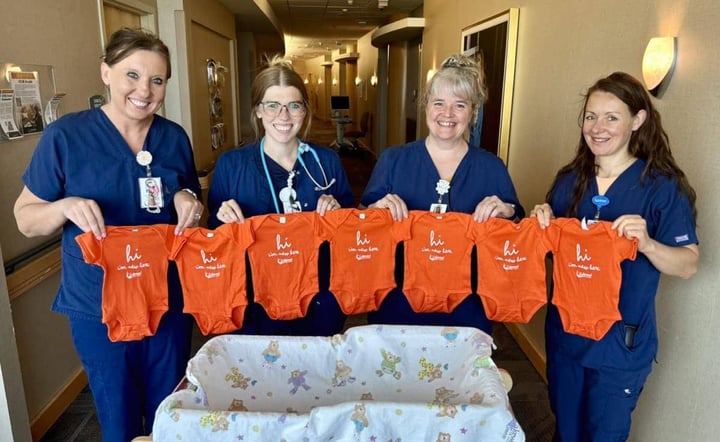 lakewood-health-system-maternity-nurses-holding-orange-baby-onesies-in-hospital-hallway-1