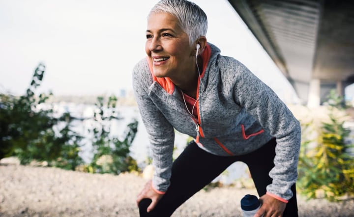 older-woman-smiling-while-stretching-outdoors-during-workout