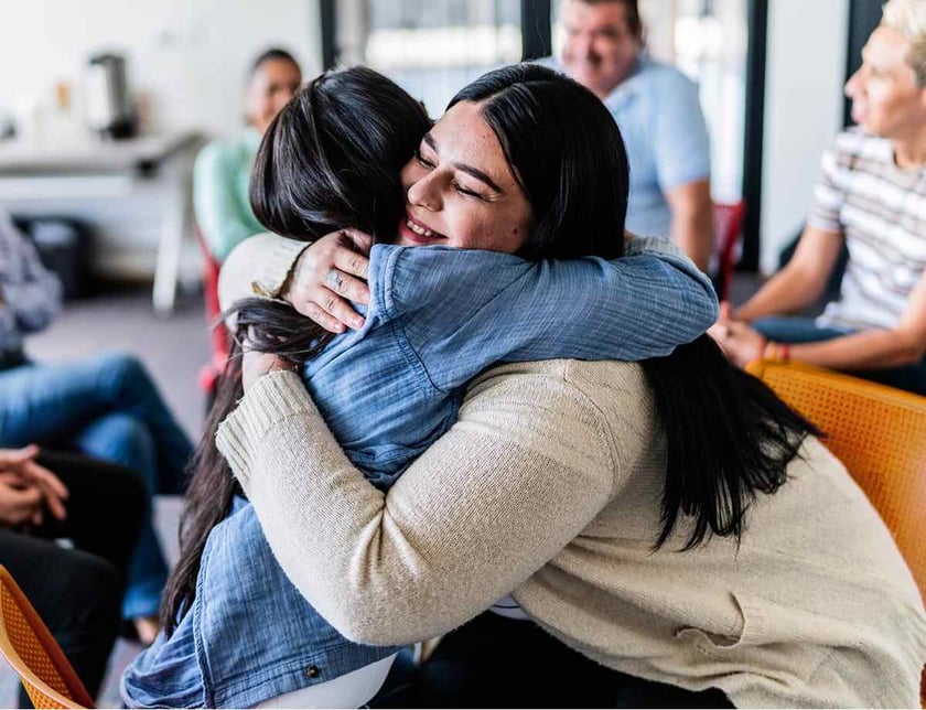Two women hug each other
