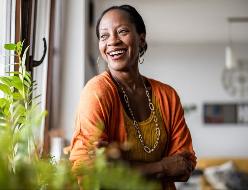 Portrait of a smiling mature woman standing in her apartment