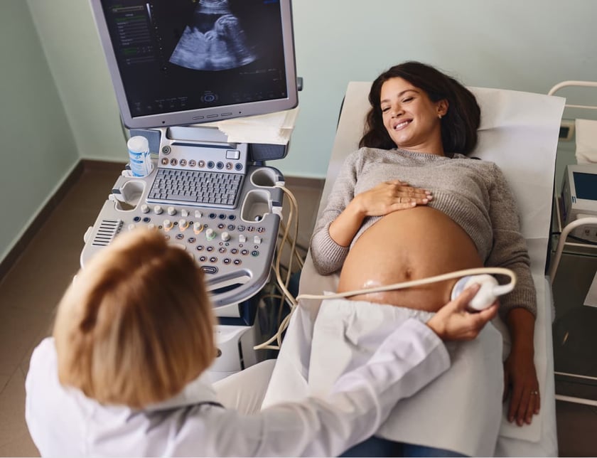 Above view of happy pregnant woman having an ultrasound while being at gynecologists'.