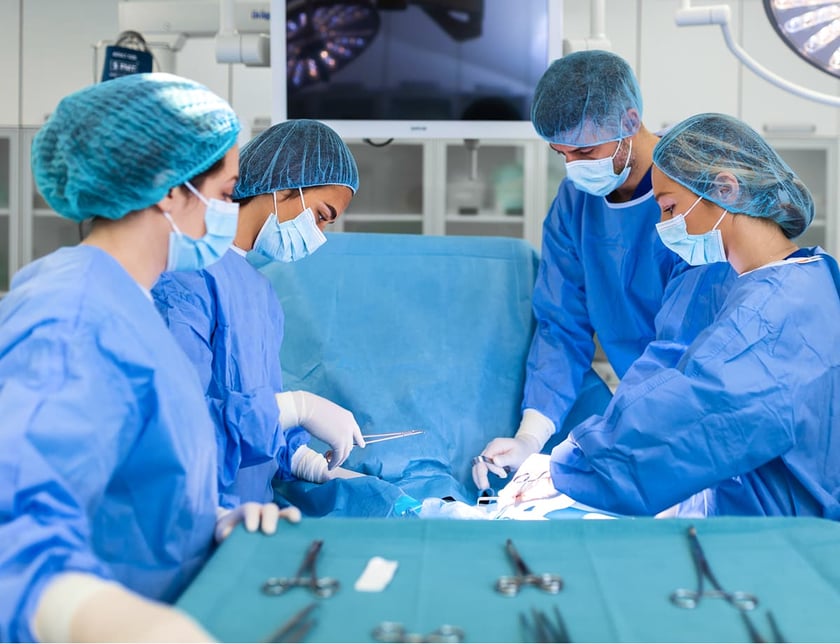 Team of professional doctors performing operation in surgery room