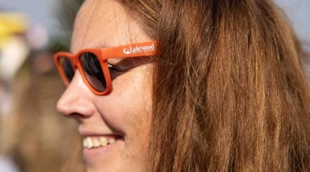 woman-smiling-wearing-lakewood-health-system-branded-orange-sunglasses